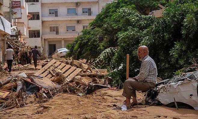 폭풍우 '다니엘' 영향으로 대홍수가 발생한 리비아 동북부 항구도시 데르나에서 12일(현지시간) 시민이 파손된 차량에 앉아 초토화된 거리를 바라보고 있다. 로이터연합뉴스
