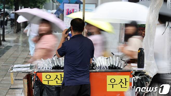 가을비가 내리는 13일 오후 서울 마포구 홍대입구역 사거리에서 우산장수가 손님을 기다리고 있다. 2023.9.13/뉴스1 ⓒ News1 이동해 기자