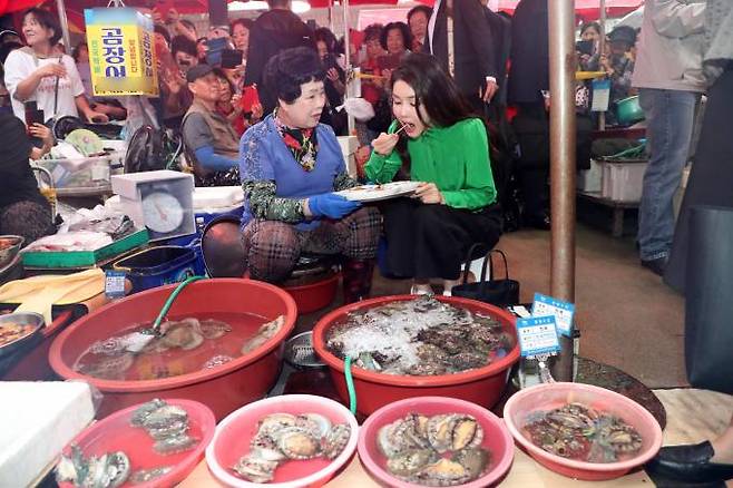 윤석열 대통령 부인 김건희 여사가 14일 부산 기장시장을 찾아 전복을 맛보고 있다.&nbsp; &nbsp;연합뉴스