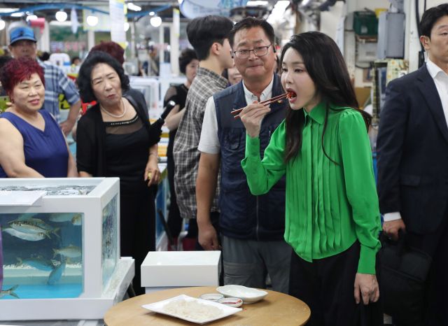 윤석열 대통령 부인 김건희 여사가 14일 부산 기장시장을 찾아 가자미회를 맛보고 있다. 연합뉴스