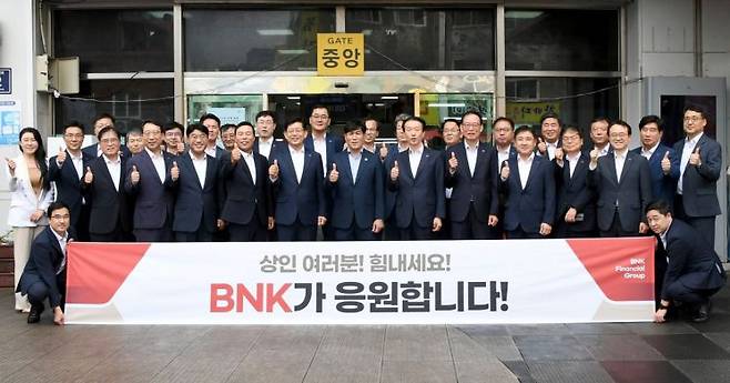 BNK임직원들이 자갈치시장 방문 단체 사진을 찍고 있다.