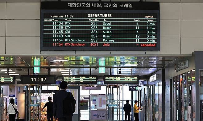 전국철도노조 파업 첫날인 지난 14일 대전역에서 열차를 기다리는 한 시민이 전광판을 지켜보고 있다. 연합뉴스