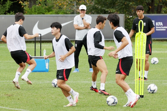 아시안게임 3연패에 도전하는 황선홍(왼쪽 세 번째) 남자축구 대표팀 감독이 14일 경기 파주 축구국가대표트레이닝센터(NFC)에서 훈련 중인 선수들을 지켜보고 있다. 조별리그 1차전까지 닷새밖에 안 남았지만 부상에서 회복 중인 이강인(파리 생제르맹)과 A대표팀에 소집된 설영우(울산 현대)의 합류가 늦어지면서 최종 엔트리 22명 중 20명만 훈련에 임했다. 뉴스1