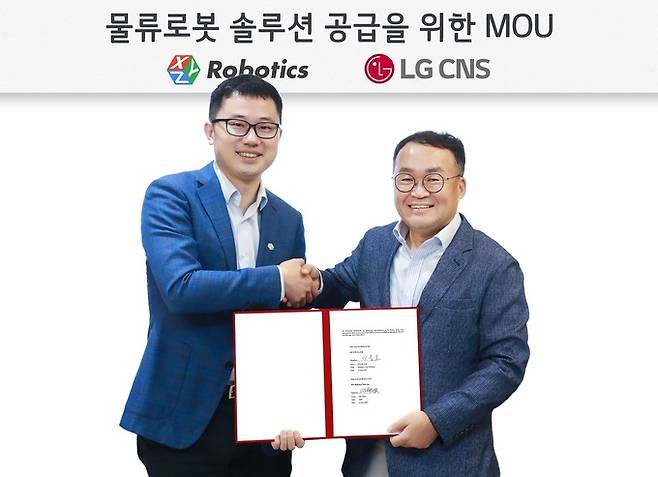 이준호 LG CNS 스마트물류사업부장 상무(오른쪽)와 지아지 저우 XYZ로보틱스 최고경영자(CEO)가 물류로봇 솔루션 공급을 위한 업무협약을 체결한 뒤 기념촬영을 하고 있다. LG CNS 제공