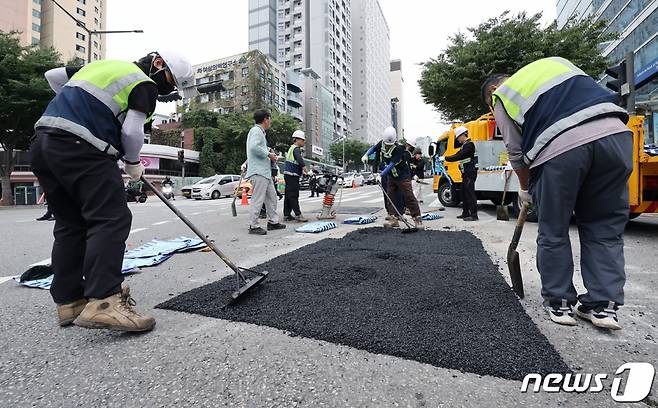 19일 서울 강남구 언주역 1~2번 출구앞 사거리에서 지름 1미터, 깊이 1.5미터 가량의 땅꺼짐(싱크홀) 현상이 발생해 관계자들이 복구작업을 하고 있다. /사진=뉴스1