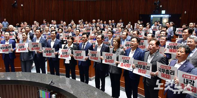 더불어민주당 의원들이 18일 서울 여의도 국회에서 열린 의원총회에서 '국무총리 해임, 내각 총사퇴' 손피켓을 들고 구호를 외치고 있다. 윤창원 기자