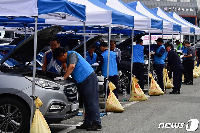 경북자동차전문정비조합 포항시지회와 검사정비사업조합 회원들이 20일 포항시 남구 포항종합운동장 앞에서 시민들의 차량을 점검하고 있다.023.9.20/뉴스1 ⓒ News1 최창호 기자