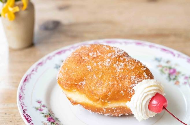 일본 도쿄 다이토구 '치가야 쿠라마에'가 판매하는 커스터드 크림 도넛. 이케다 히로아키(池田浩明)씨는 “빨강과 흰색이 섞인 가련한 모습 속 쫀득쫀득 식감과 동시에 가벼운 목 넘김, 리치함과 산뜻함이 기적적으로 공존한다”고 말했다.