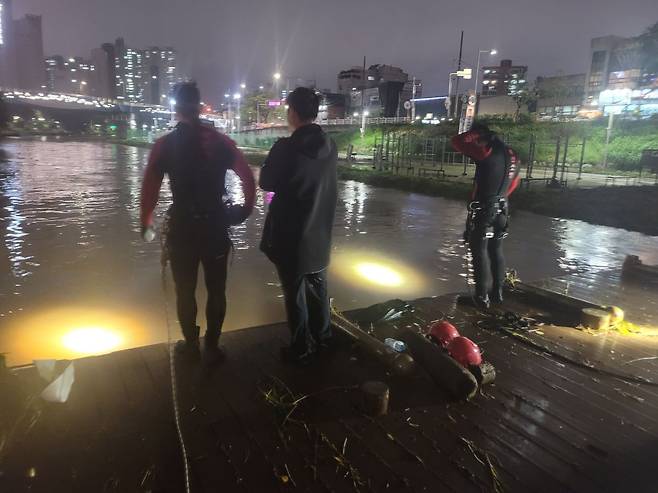 20일 오후 부산 금정구 온천천 산책로에서 폭우로 불어난 물에 고립된 한 여성이 기둥을 붙잡고 있다가 실종됐다. 부산소방본부 대원 100여 명과 원격수중탐사장비 등을 투입해 수색 작업을 벌이고 있다. /부산소방재난본부