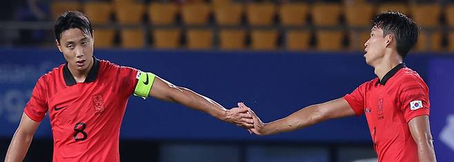 항저우 아시안게임 남자 축구대표팀의 주장 백승호(왼쪽)가 19일 중국 저장성 진화스포츠센터 경기장에서 열린 쿠웨이트와의 조별리그 1차전 전반전을 마친 뒤 정우영을 격려하고 있다. 진화 | 연합뉴스
