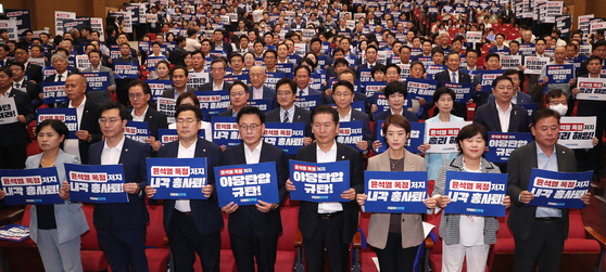 Lawmakers from the liberal Democratic Party (DP) hold up placards and chant slogans criticizing the Yoon Suk Yeol administration and prosecutors' latest move to arrest DP leader Lee Jae-myung at the National Assembly in Yeouido, western Seoul, on Wednesday. [YONHAP]