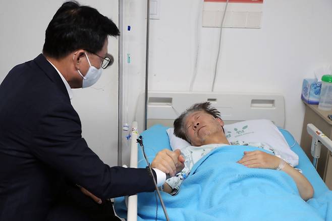 박광온 더불어민주당 원내대표가 21일 오전 서울 중랑구 녹색병원을 찾아 단식 중인 이재명 대표의 손을 잡고 대화하고 있다./뉴스1