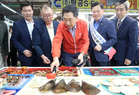 김기현 국민의힘 대표(가운데)가 22일 오후 대구 북구 대구농수산물도매시장을 찾아 수산법인대표 간담회를 마친 뒤 판매용 수산물에 대한 방사능을 측정하고 있다. 뉴스1