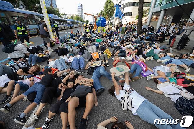 23일 오후 서울 중구 서울시청역 인근에서 열린 9·23 기후정의행진에서 참가자들이 대통령실 방향으로 행진하는 도중 바닥에 눕는 퍼포먼스를 하고 있다. 2023.9.23/뉴스1 ⓒ News1 이재명 기자