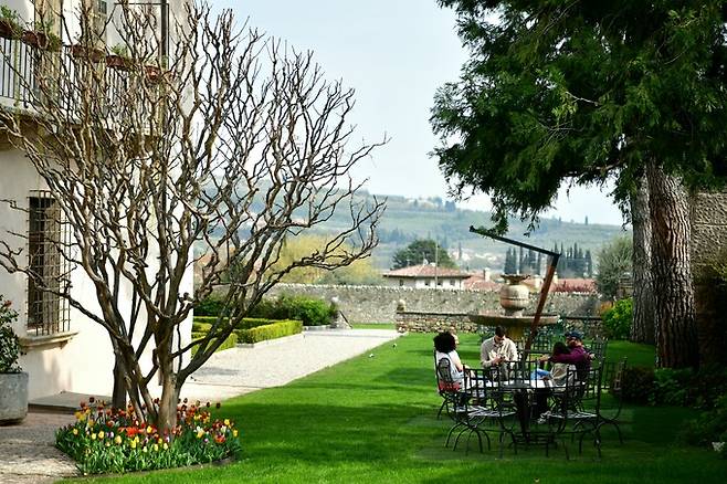 알레그리니 빌라 델라 토레 정원에서 와인을 즐기는 방문객.
