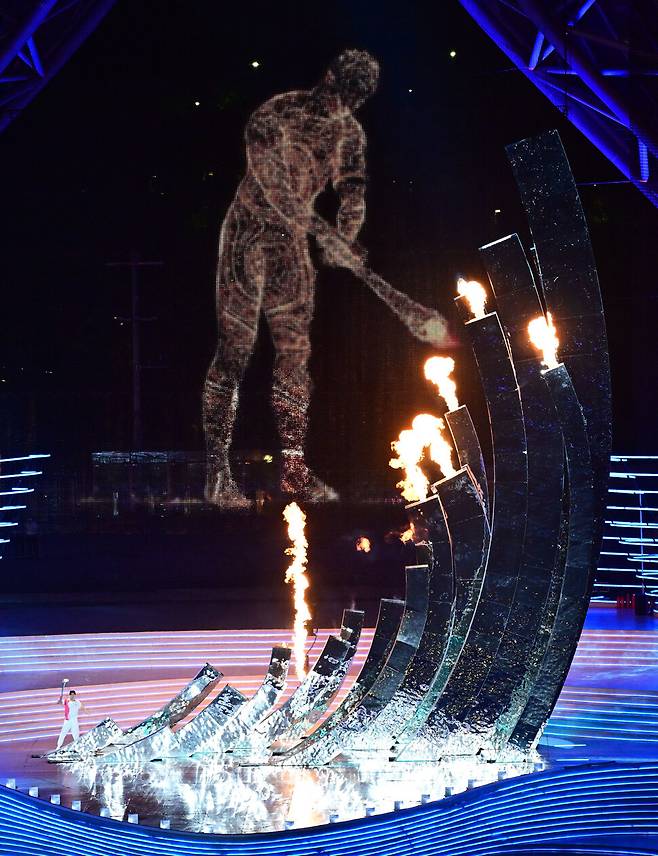 23일 중국 항저우 올림픽 스포츠센터 스타디움에서 열린 항저우아시안게임 ‘인간 대표’ 왕순과 ‘가상 현실’ 대표 디지털 성화 봉송 주자가 함께 불을 붙이고 있다. 공동취재사진