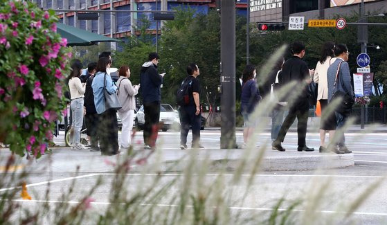 서울 최저기온이 16도까지 떨어지며 선선한 가을날씨를 보인 22일 오전 서울 세종대로사거리에서 긴팔과 외투를 입은 출근길 시민들의 모습. 뉴스1