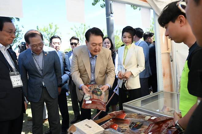 윤석열 대통령과 김건희 여사가 24일 서울 용산어린이정원에서 추석을 앞두고 열린 '추석맞이 팔도장터'를 찾아 제수용품을 살펴보고 있다. [연합]