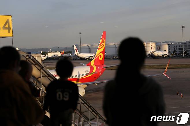 2021년 5월 9일(현지시간) 중국 베이징 국제공항 여객기 앞에서 여행객들의 모습이 보이고 있다. 2021.05.09/ ⓒ 로이터=뉴스1 ⓒ News1 임윤지 기자