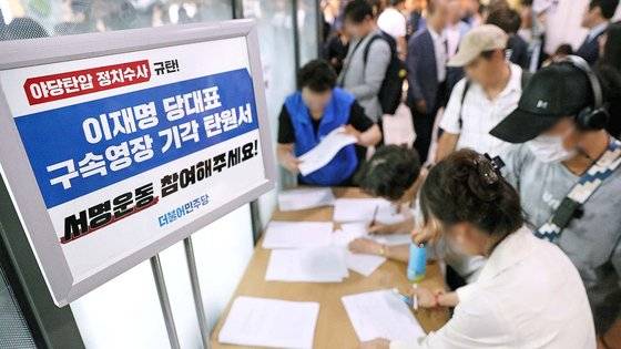 24일 오후 서울 강서구 양천구 진교훈 더불어민주당 강서구청장 후보자 선거사무소에서 민주당 지지자들이 이재명 대표 구속영장 기각 탄원서에 서명을 하고 있다. 뉴스1