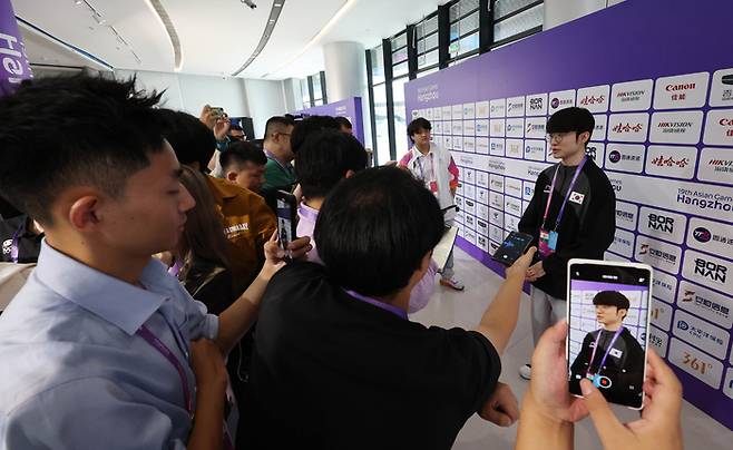 25일 오전 중국 항저우 e스포츠 센터에서 열린 항저우 아시안게임 e스포츠 리그 오브 레전드(LoL)에 출전한 국가대표팀 ‘페이커’ 이상혁이 8강에 진출한 뒤 취재진을 만나 소감을 밝히고 있다. 취재진이 뜨거운 취재 열기를 과시하고 있다. [사진 출처=연합뉴스]