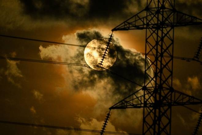 〈3rd Supermoon can be seen between transmission towers in Aceh, Indonesia. Yonhap News = AFP〉