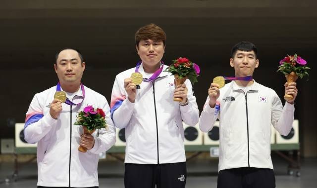 25일 중국 항저우 푸양 인후 스포츠센터에서 열린 제19회 항저우 아시안게임 남자 10m 러닝타깃 단체전에서 금메달을 획득한 하광철, 정유진, 곽용빈이 시상대에 올라 기뻐하고 있다. 연합뉴스