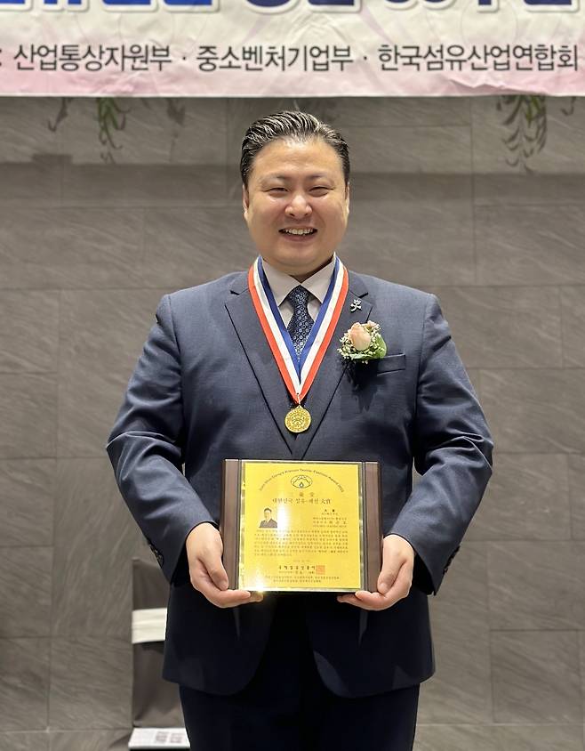 최준호 패션그룹형지 대표가 ‘제30회 삼우당 섬유패션진흥대상’ 내수패션 부문 대상을 수상한 뒤 상패를 들고 기념촬영을 하고 있다. [패션그룹형지 제공]