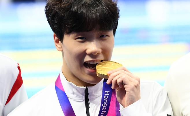 ▲ 2022 항저우 아시안게임 수영 남자 자유형 50m에서 우승한 지유찬이 메달을 깨무는 세리머니를 하고 있다. ⓒ연합뉴스