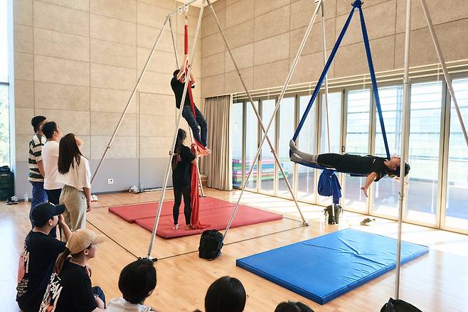 Participants try out aerial silk performing during a "Circus Playground" workshop. (LG Arts Center)