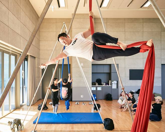 Participants try out aerial silk performing during a "Circus Playground" workshop. (LG Arts Center)