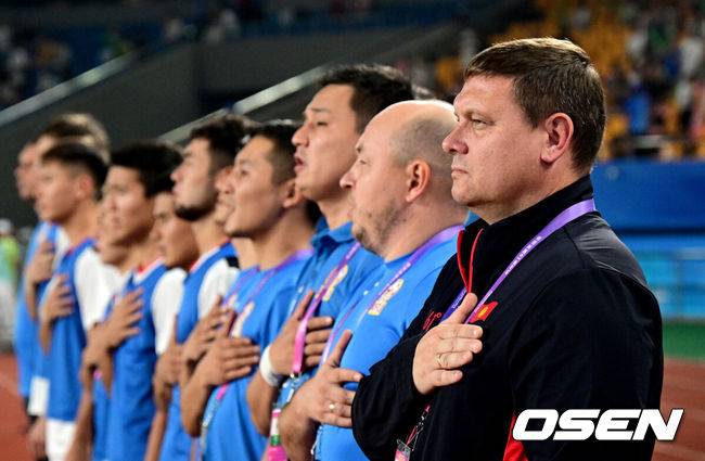 [OSEN=진화(중국), 최규한 기자] 27일 오후 중국 진화 스포츠센터 스타디움에서 '제19회 항저우아시아게임' 남자축구 16강전 대한민국과 키르기스스탄의 경기가 열렸다.경기 시작을 앞두고 키르키스스탄 리시친 막심 감독이 국기에 대한 경례를 하고 있다. 2023.09.27 / dreamer@osen.co.kr