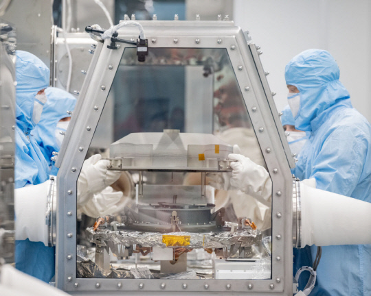 미국 과학자들이 소행성 탐사선 '오시리스-렉스'가 가져온 소행성 샘플 캡슐의 뚜껑을 제거하고 있다.  사진=나사