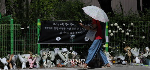 한 시민이 지난 8월 15일 성남시 분당구 서현역 부근에 마련된 피해자 추모 공간에 꽃을 놓고 있다.  김창길기자