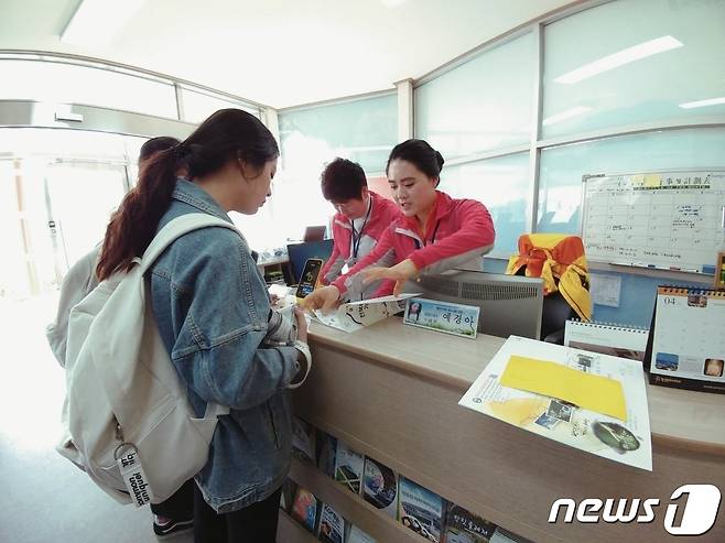 예경화씨가 무주광광사업소에서 관광객에게 책자를 보여주며 무주 곳곳을 안내하고 있다.(무주군 제공)2023.9.29./뉴스1