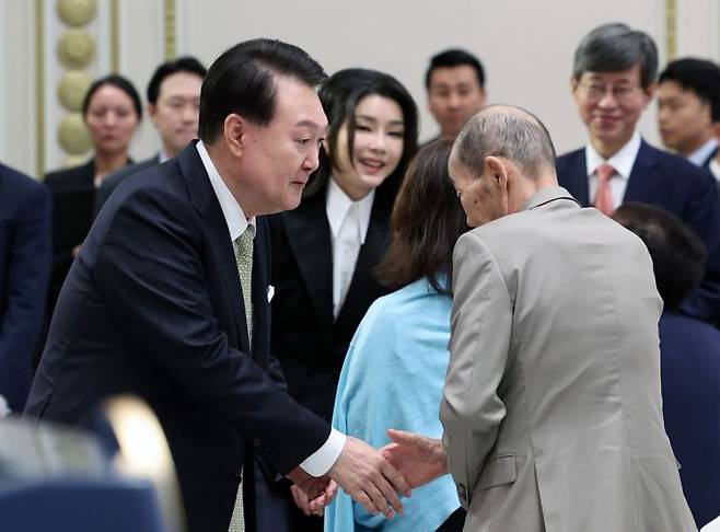 윤석열 대통령과 김건희 여사는 추석인 29일 청와대 영빈관에서 열린 원폭 피해 동포 오찬 간담회에 입장하며 참석자들과 인사하고 있다. [이미지출처=연합뉴스]