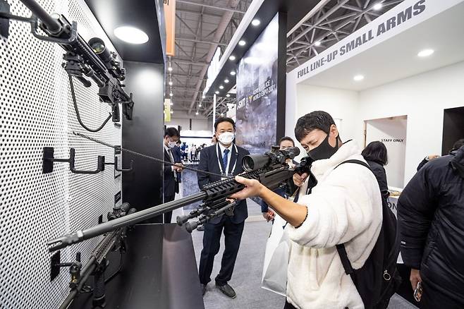 인천시 송도 컨벤시아에서 열린 '제3회 국제치안산업박람회(KPEX 2021)'에서 한 방문객이 SNT모티브 7.62㎜ K-14 저격용 소총을 들어 조준경을 살펴보고 있다. SNT모티브 제공.