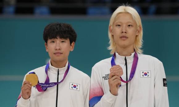 30일 중국 항저우 첸탕 롤러스포츠센터에서 열린 항저우 아시안게임 남자 스피드 롤러스케이팅 스피드 제외 포인트(EP) 1만ｍ 결승에서 금메달을 따낸 한국 정병희(왼쪽)와 동메달을 획득한 최인호가 시상식에서 메달을 들어보이고 있다. [사진=뉴시스]