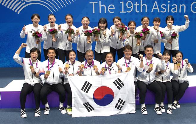 1일 항저우 아시안게임 배드민턴 여자 단체전 금메달을 획득한 한국 선수들과 코칭스태프가 태극기를 들고 기념 촬영을 하고 있다. /김동환 기자