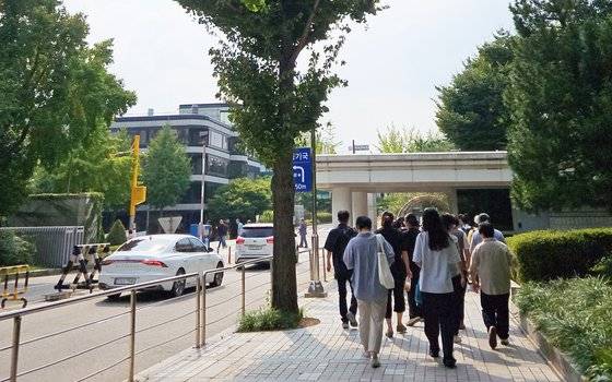 지난달 11일 서울 서초동 서울중앙지법 서관 앞에서 창원간첩단(자통)의 공판기일 변경 사실을 알게 된 지지자들이 단체사진을 찍으러 이동하고 있다. 김정민 기자