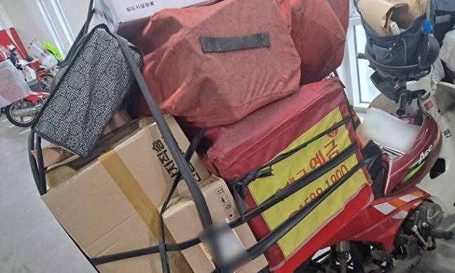 지난달 25일 수도권 한 우체국에 근무하는 집배원이 배달할 우편물을 오토바이에 적재한 모습이다. 적재함 바깥에 짐을 올려 끈으로 고정했는데 과도한 중량으로 운행 중 중심을 잡기 어렵다고 설명했다. 민주노총 공공운수노조 전국민주우체국본부 제공