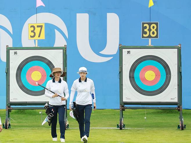 대한민국 양궁 여자 리커브 대표팀 임시현(왼쪽)과 안산이 30일 중국 항저우 푸양 인후 스포츠센터 양궁장에서 2022 항저우 아시안게임 양궁 리커브 여자 개인 예선을 하루 앞두고 공식 연습 중 과녁의 활을 회수한 뒤 돌아오고 있다. 2023.9.30 연합뉴스