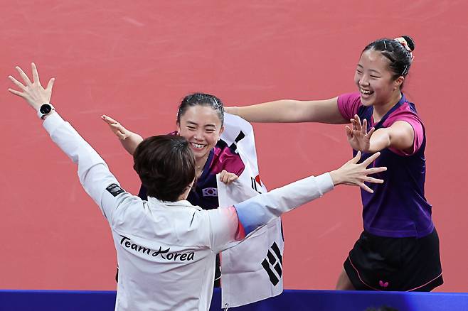 2일 중국 항저우 궁수 캐널 스포츠파크 체육관에서 열린 19회 항저우 아시안게임 탁구 여자 복식 결승전에서 한국 신유빈-전지희가 북한 차수영-박수경을 꺾고 금메달을 확정지은 후 '2002년 부산 대회 금메달 레전드' 석은미 코치와 포옹하며 기뻐하고  있다. <저작권자(c) 연합뉴스, 무단 전재-재배포 금지>