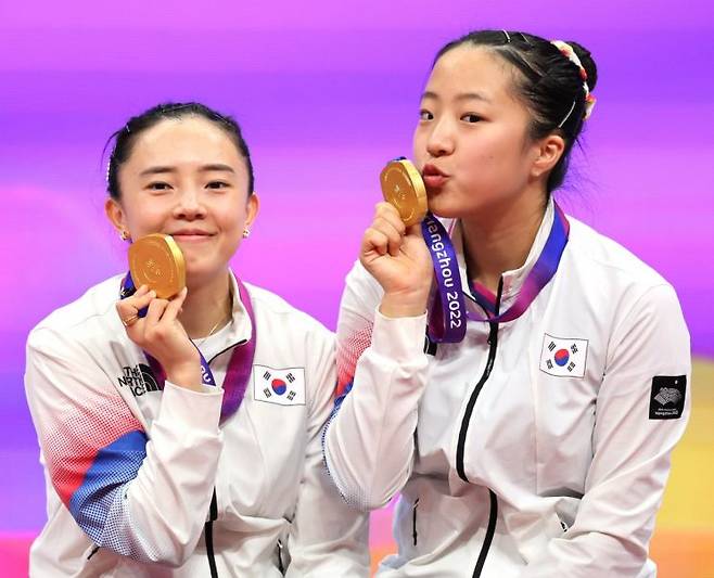 2일 중국 항저우 궁수 캐널 스포츠파크 체육관에서 열린 19회 항저우 아시안게임 탁구 여자 복식 결승전에서 한국 신유빈-전지희가 북한 차수영-박수경에 승리, 금메달을 차지한 후 시상식에서 메달을 들어보이고 있다. [이미지출처=연합뉴스]