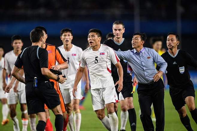 2022 항저우 아시안게임 남자 축구 8강전에서 일본에 패배한 이후 심판에게 항의하는 북한 선수들 / AFP=연합뉴스