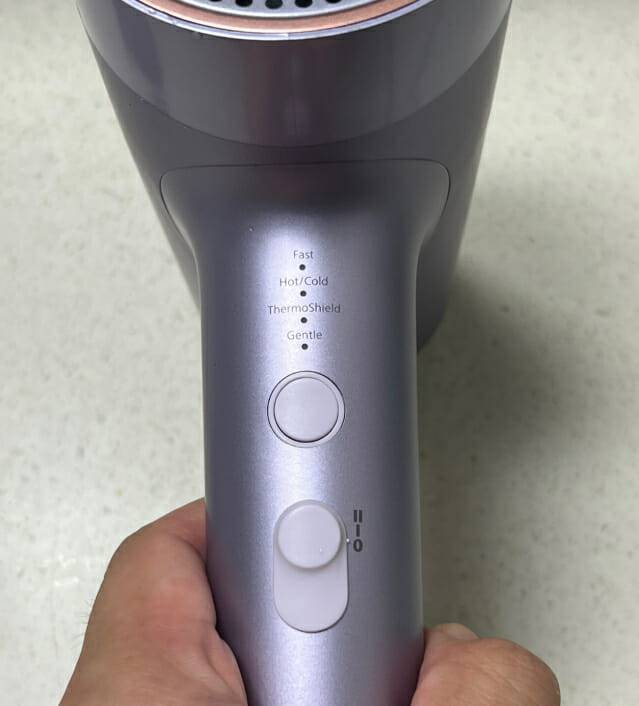 필립스 7000 시리즈 헤어드라이기 후면 조작부. 위쪽 버튼을 누르면 온도 조절 모드가 변경된다. 아래 슬라이드 버튼은 전원 겸 바람 세기 조절 기능 (사진=신영빈 기자)