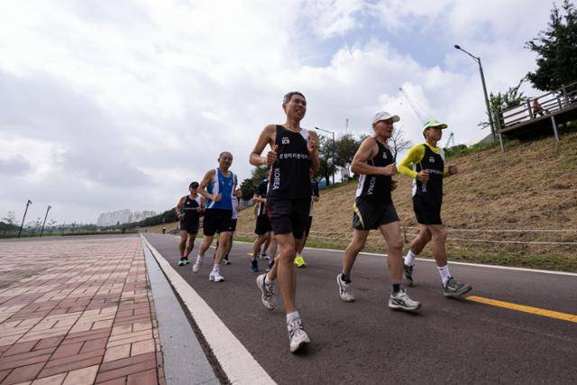 최명남(앞줄 가운데)씨가 9월 17일 '광명마라톤에이스' 회원들과 함께 경기 광명시 안양천 둑길을 달리고 있다. 광명=이한호 기자