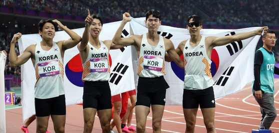 3일 중국 항저우 올림픽 스포츠센터에서 열린 2022 항저우 아시안게임 남자 400ｍ 계주 결선에서 동메달을 차지한 대한민국 선수들이 태극기를 펼치며 기뻐하고 있다.   왼쪽부터 김국영, 이정태, 이재성, 고승환.연합뉴스