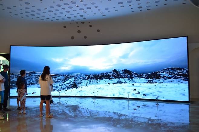 Visitors watch a short film on the ice age. (Kim Hae-yeon/ The Korea Herald)