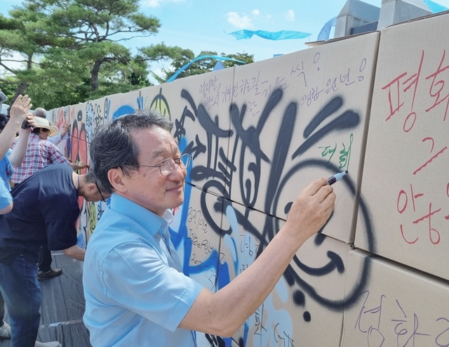 지난 7월 27일 '2023 세계예술인 평화선언'에서 유 대표이사가 '평화의벽'에 평화메시지를 작성하고 있다. 경기문화재단 제공